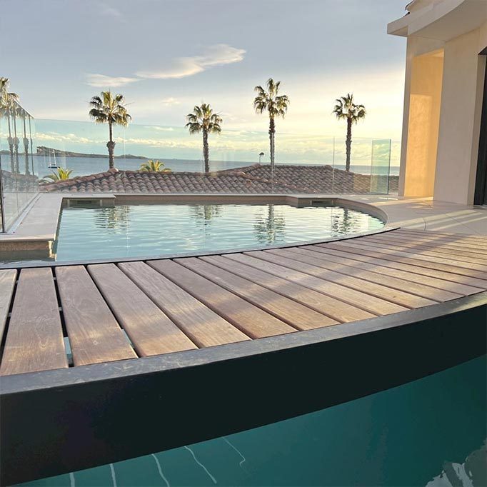 Piscine à débordement rénovée, terrasse en bois et vue sur la mer au coucher du soleil